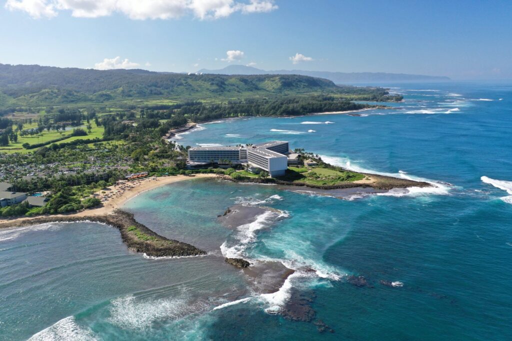 Aerial view of the Turtle Bay coastline on Oahu's North Shore, with surf breaking on the reef