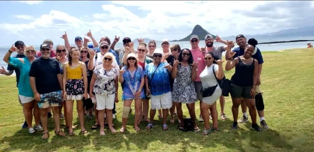 Aloha Fantasy Tours guests posing in front of Mokoliʻi Island on Oahu's windward coast