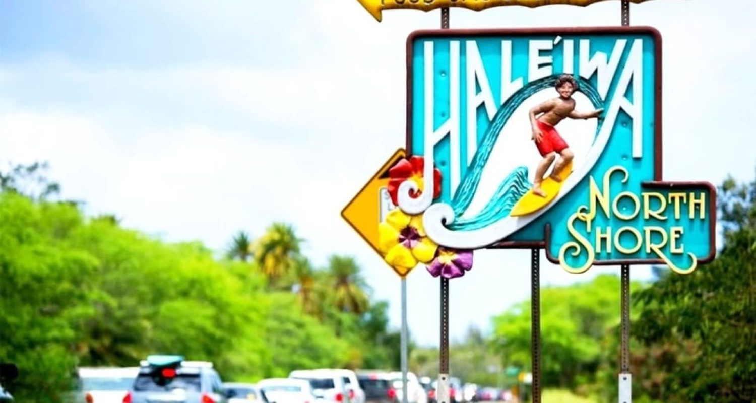 Traffic on Kamehameha Highway passing the Haleiwa North Shore sign