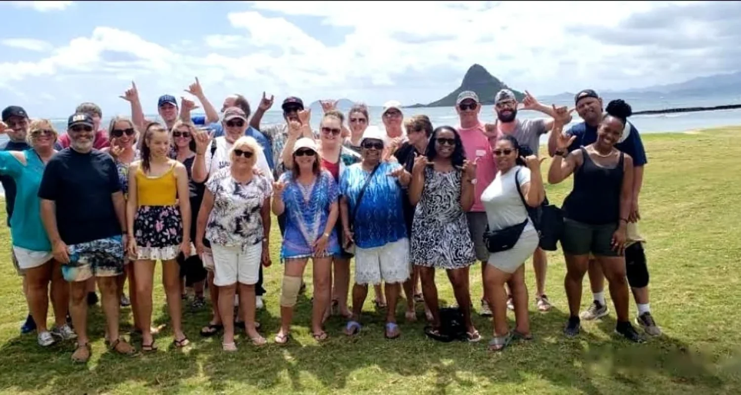 Aloha Fantasy Tours guests posing in front of Mokoliʻi Island on Oahu's windward coast